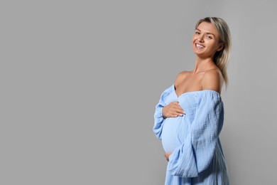 Photo of Portrait of beautiful pregnant woman on grey background, space for text