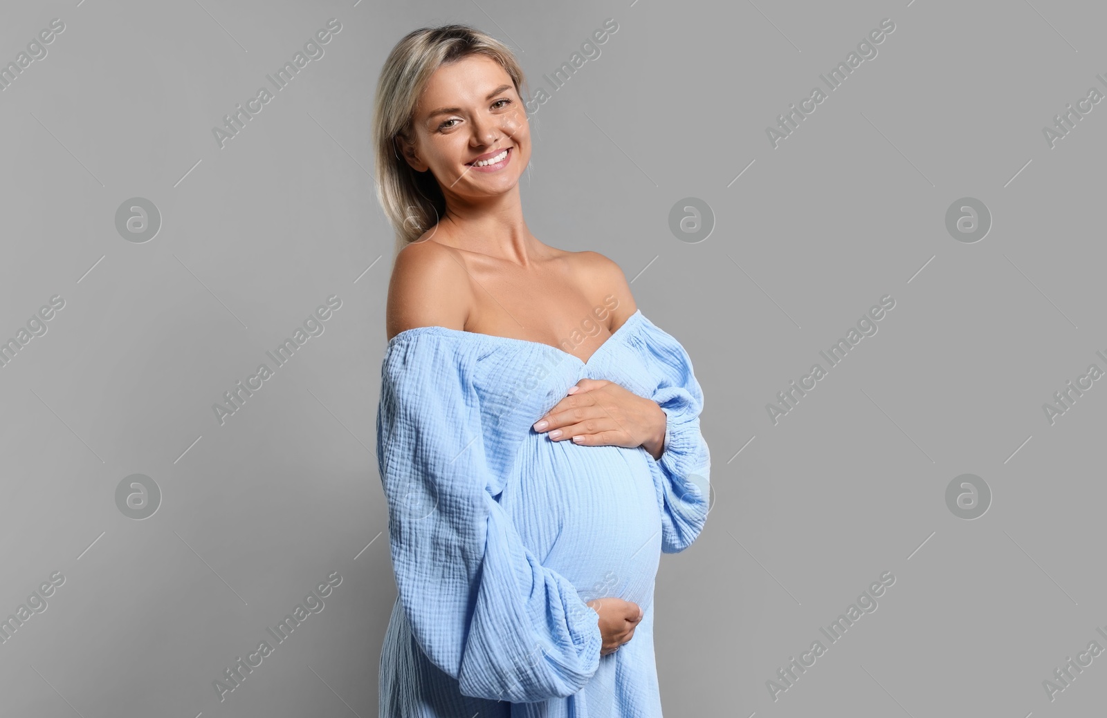 Photo of Portrait of beautiful pregnant woman on grey background