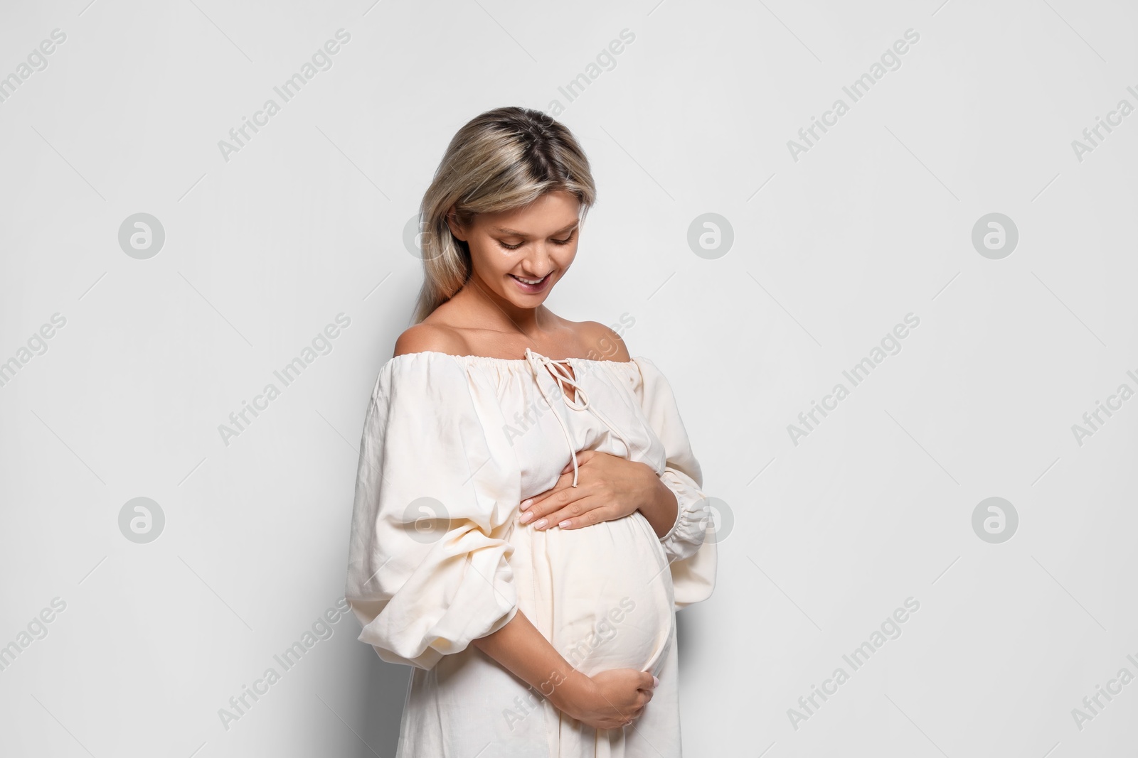 Photo of Portrait of beautiful pregnant woman on white background