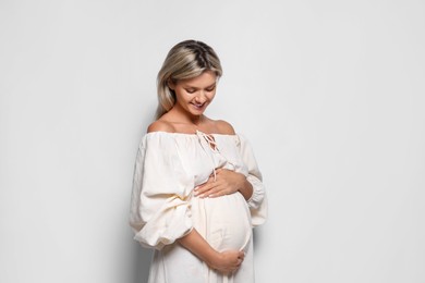 Portrait of beautiful pregnant woman on white background