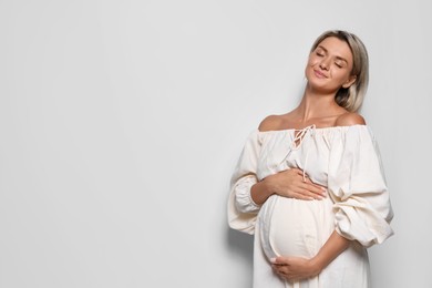 Photo of Portrait of beautiful pregnant woman on white background, space for text