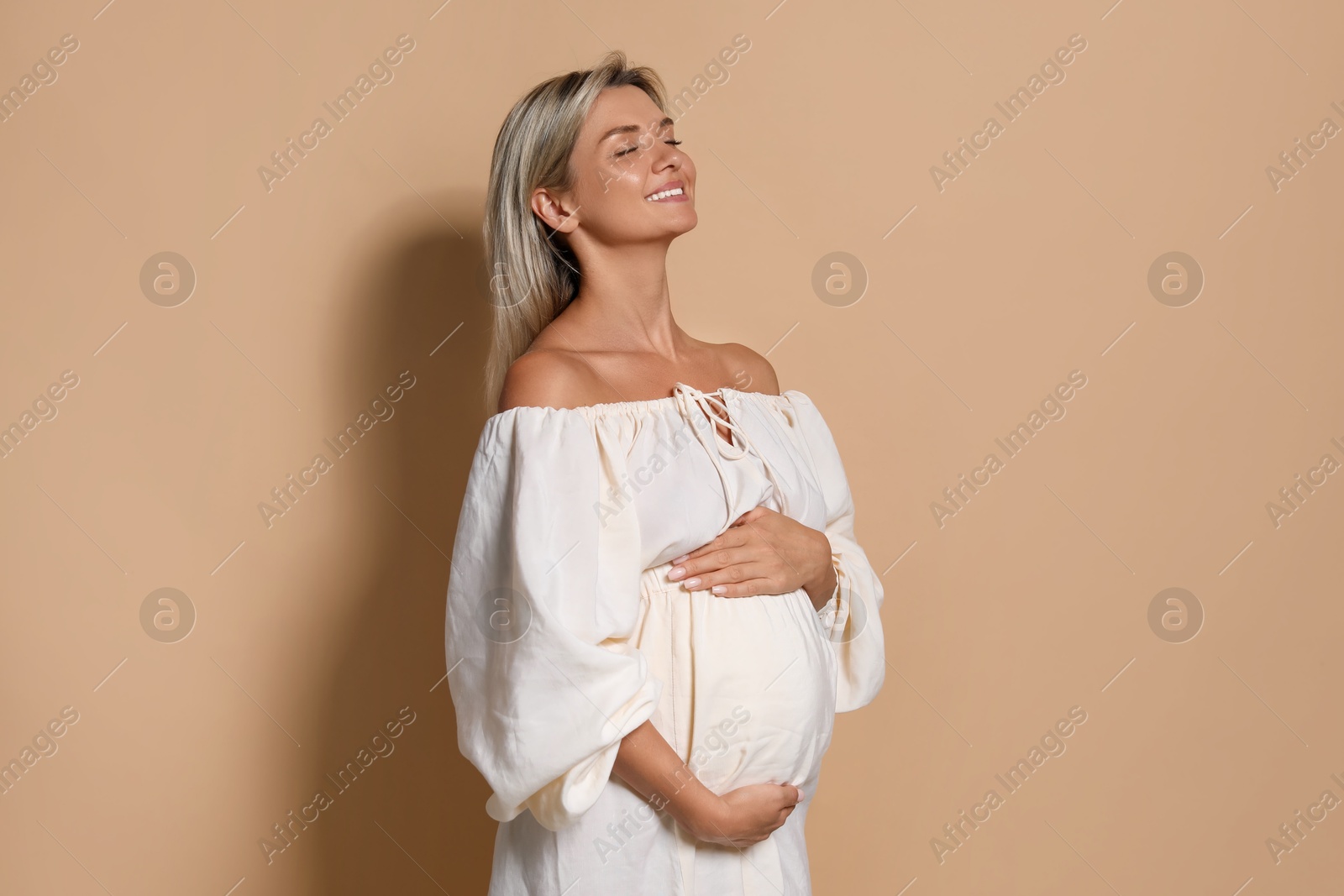 Photo of Portrait of beautiful pregnant woman on beige background