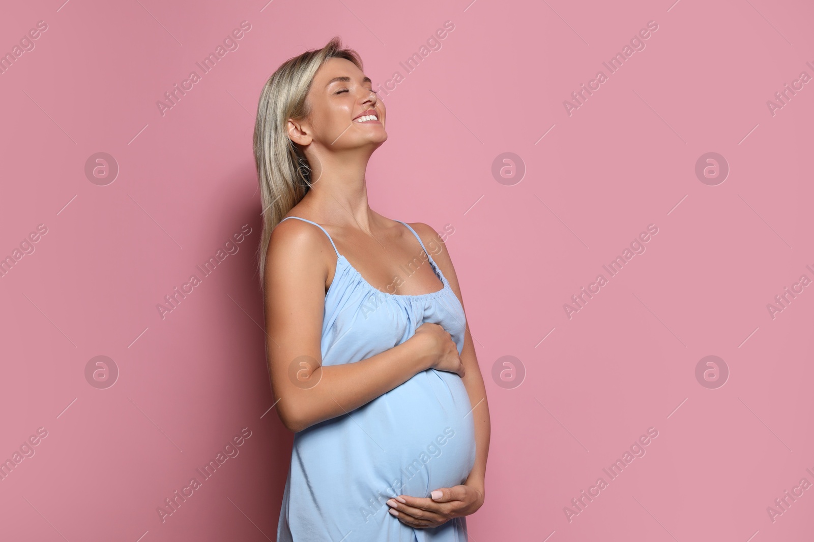 Photo of Portrait of beautiful pregnant woman on pink background