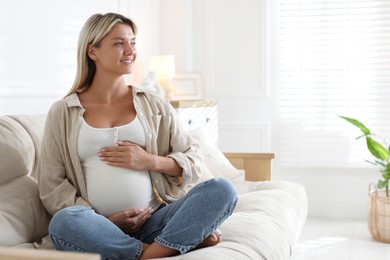 Photo of Portrait of beautiful pregnant woman on sofa at home