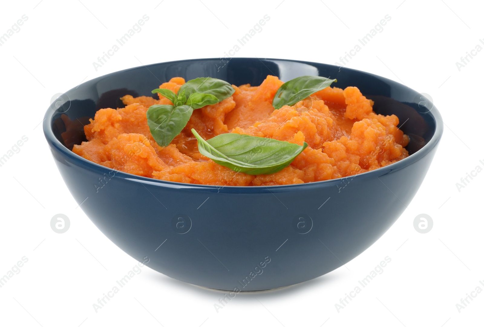 Photo of Tasty mashed sweet potato with basil in bowl isolated on white