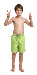 Photo of Happy little boy in beachwear showing peace sign on white background