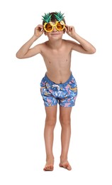 Little boy in beachwear and sunglasses on white background