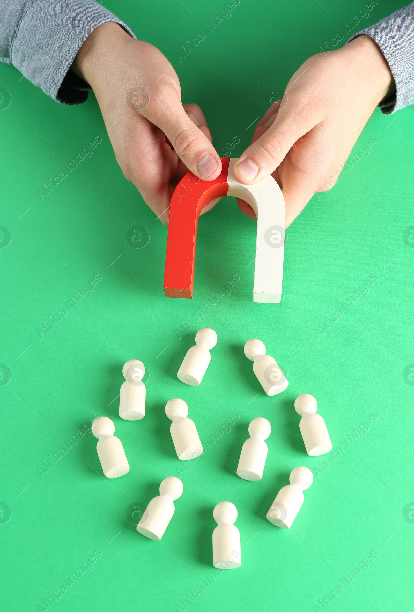 Photo of Man with magnet attracting game pieces at green table, above view