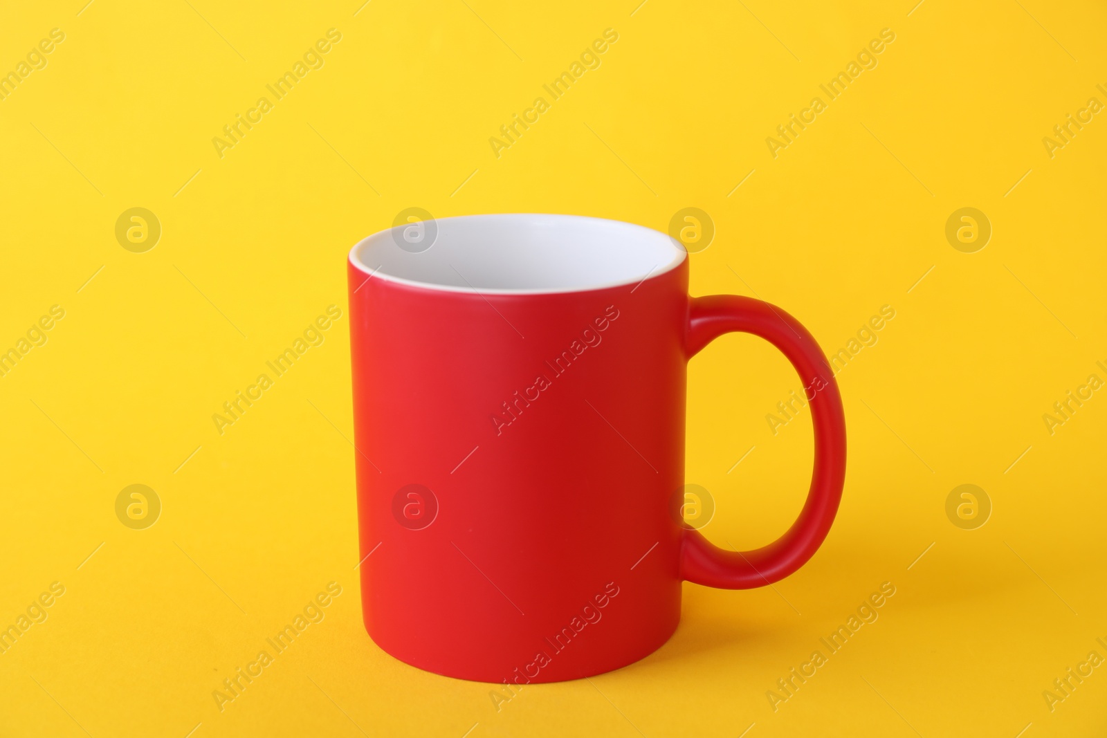 Photo of One blank red mug on yellow background. Mockup for design