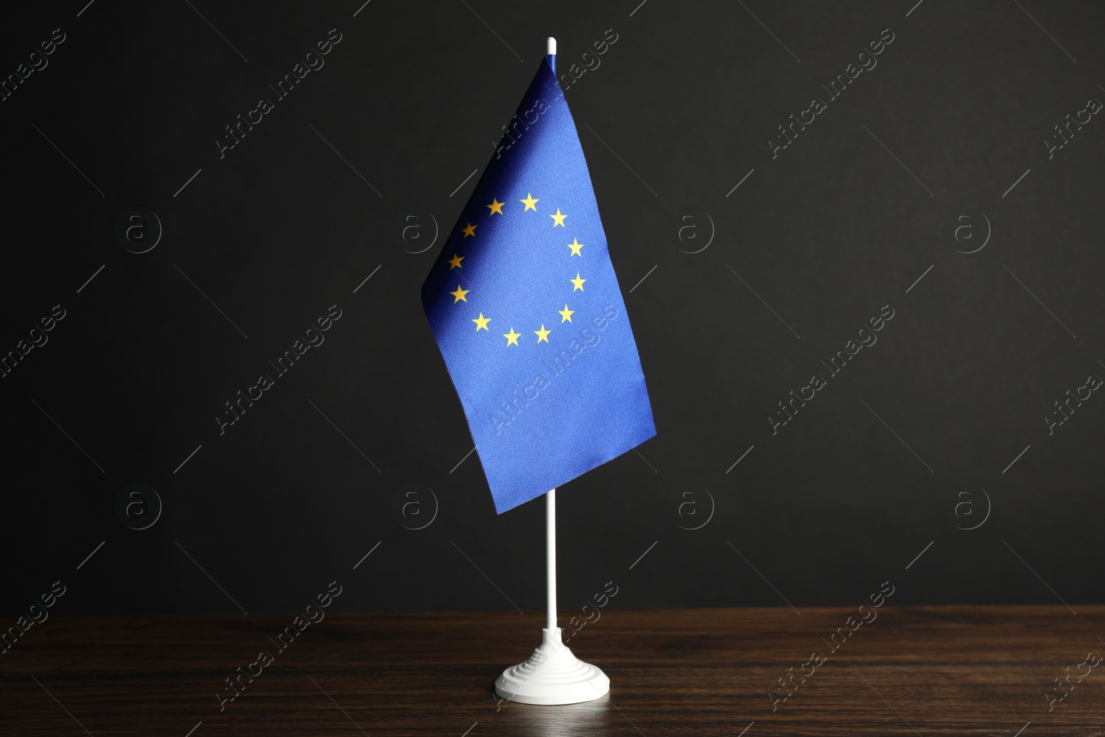 Photo of One flag of European Union on wooden table against black background