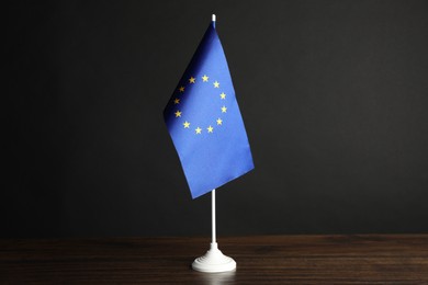 Photo of One flag of European Union on wooden table against black background