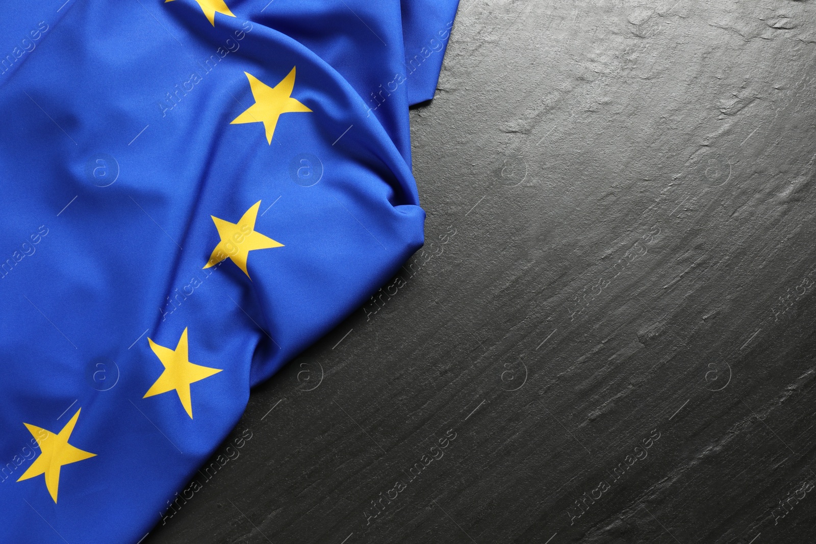 Photo of Flag of European Union on black textured background, top view. Space for text