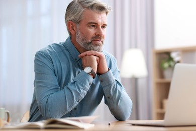 Photo of Middle aged man working at table indoors