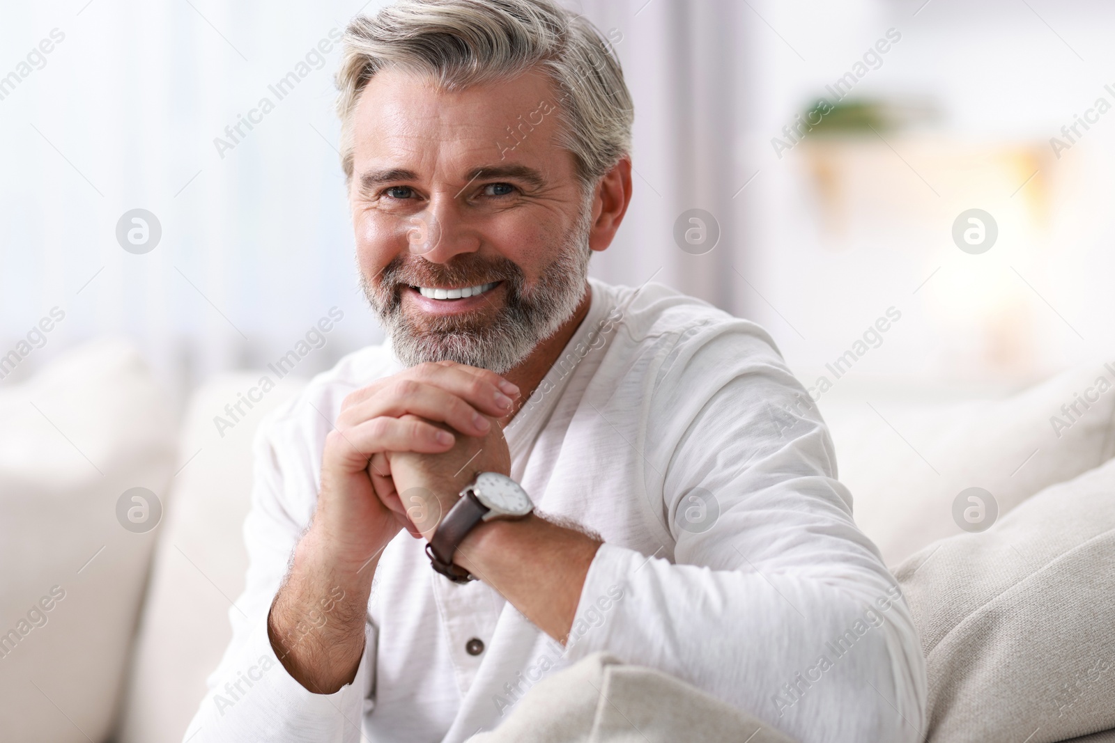 Photo of Portrait of happy middle aged man on sofa at home