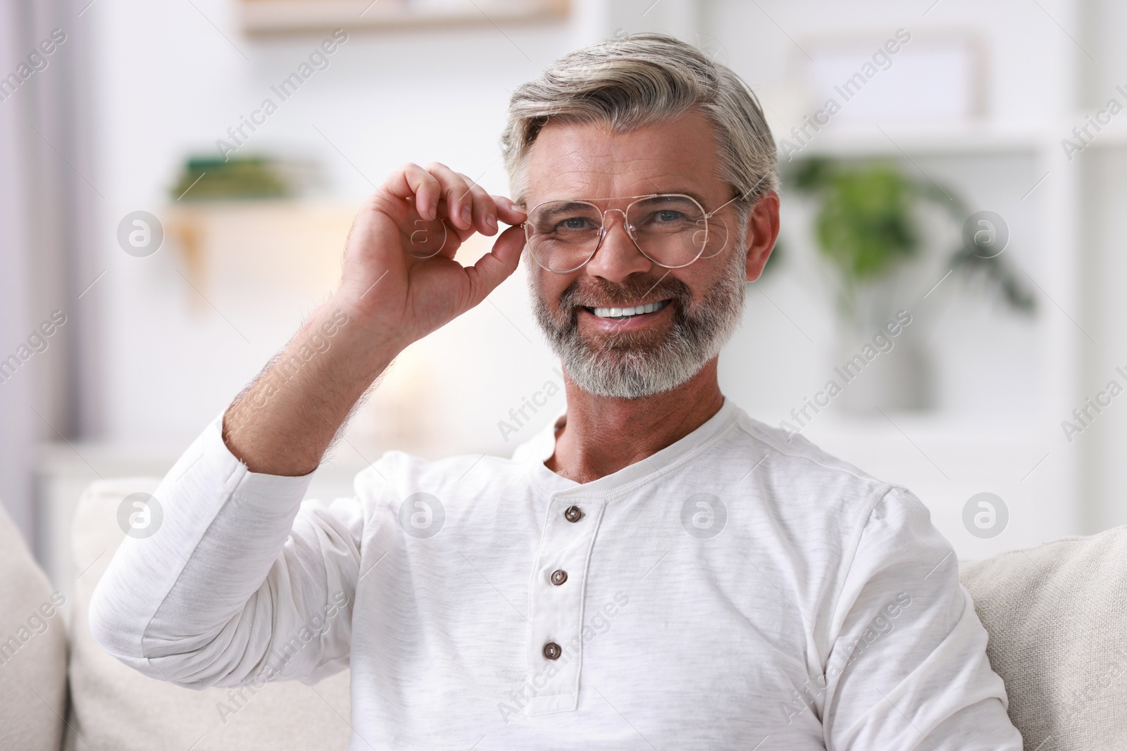 Photo of Portrait of happy middle aged man on sofa at home