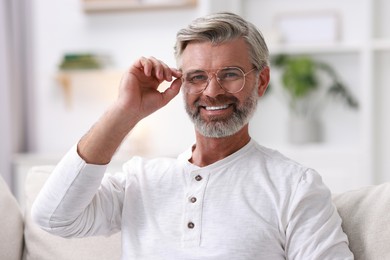 Photo of Portrait of happy middle aged man on sofa at home