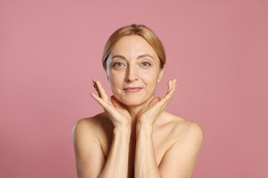 Portrait of beautiful woman with healthy skin on pink background