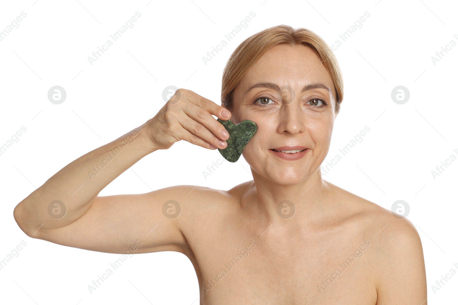 Photo of Smiling woman doing facial self massage with gua sha tool on white background