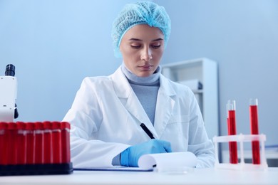 Laboratory testing. Doctor taking notes at table indoors