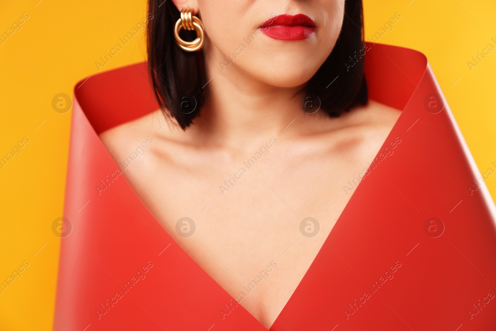 Photo of Young woman posing on orange background, closeup