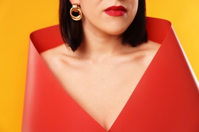 Photo of Young woman posing on orange background, closeup