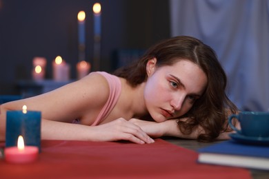 Photo of Beautiful young woman posing at table in room. Fashion vintage style portrait