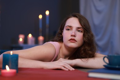 Beautiful young woman posing at table in room. Fashion vintage style portrait