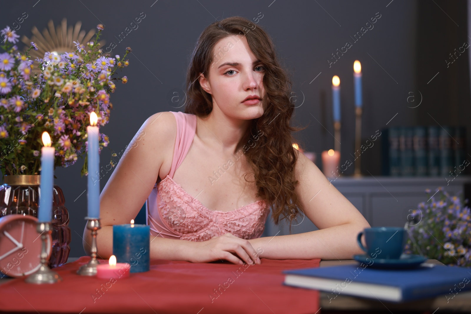 Photo of Beautiful young woman sitting at table in room. Fashion vintage style portrait