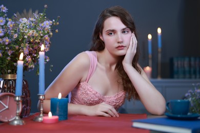 Photo of Beautiful young woman sitting at table in room. Fashion vintage style portrait