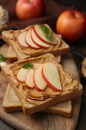 Photo of Tasty sandwiches with peanut butter, apples and mint on table, closeup