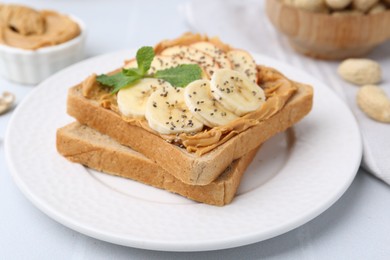 Photo of Tasty sandwich with peanut butter, apple, banana, chia seeds and mint on table, closeup