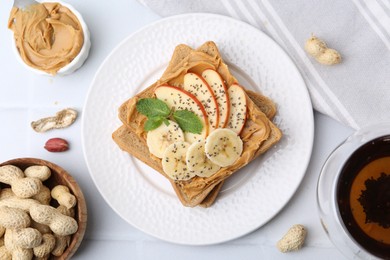 Photo of Tasty sandwich with peanut butter, apple, banana, chia seeds, nuts and mint on white table, flat lay