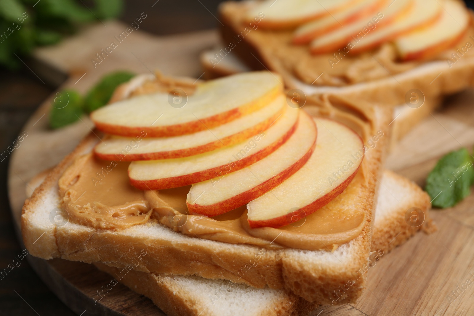 Photo of Tasty sandwiches with peanut butter and apple on table, closeup