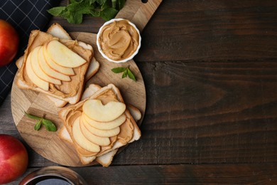 Photo of Tasty sandwiches with peanut butter, apples and mint on wooden table, flat lay. Space for text