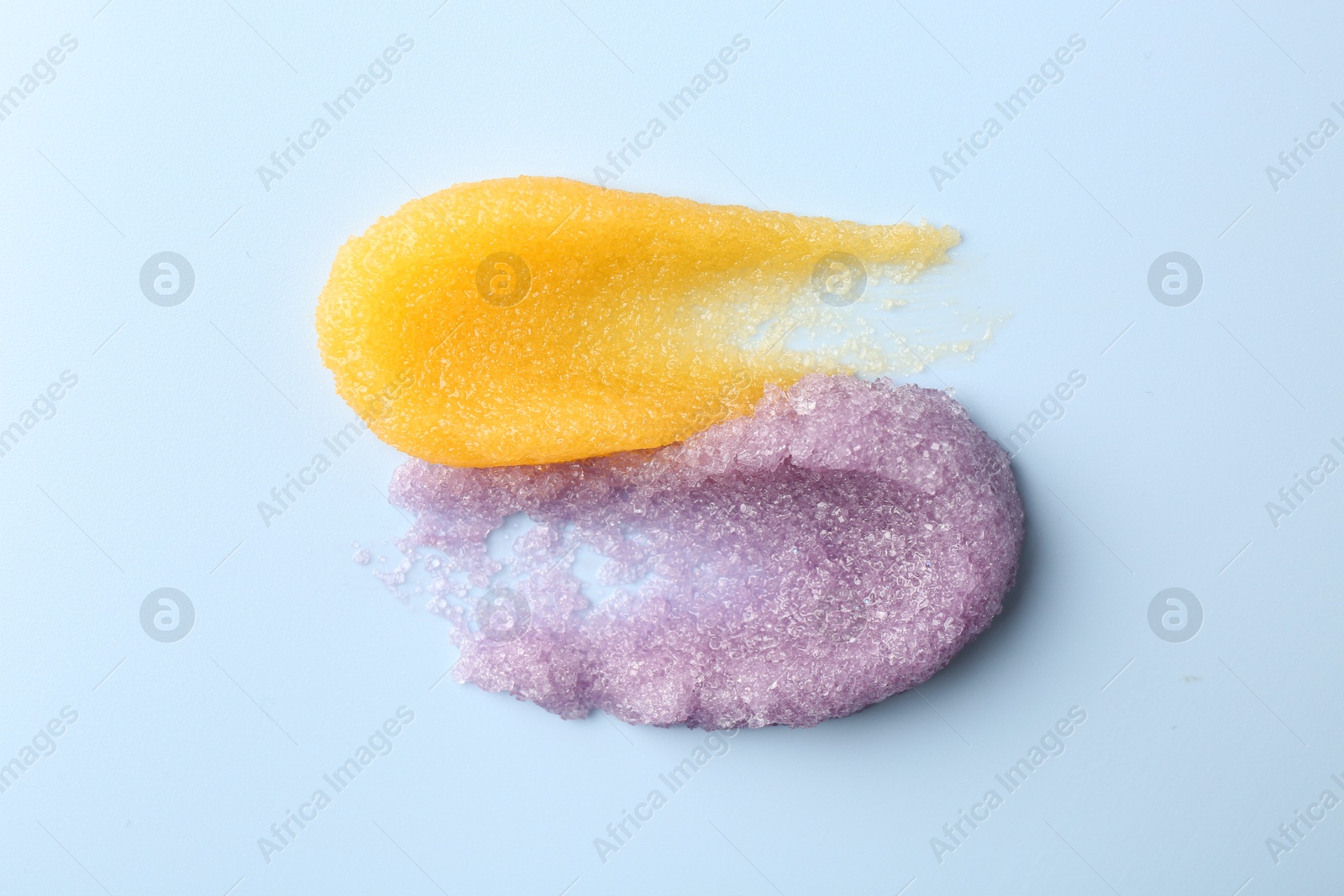 Photo of Smears of body scrubs on light background, top view