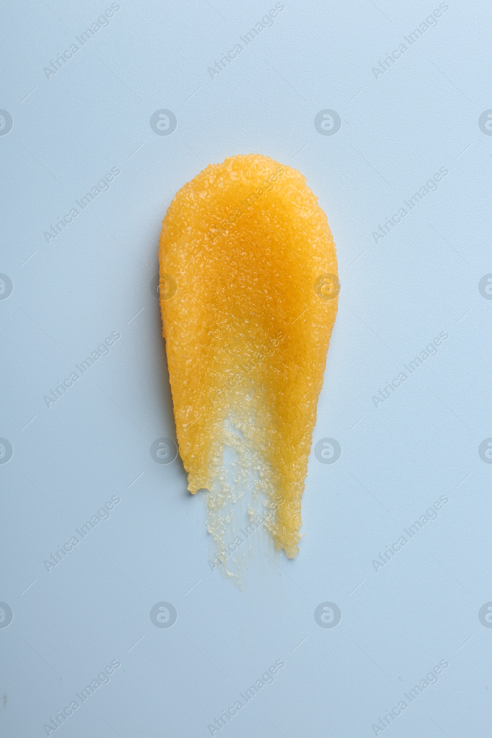 Photo of Smear of body scrub on light background, top view