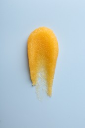 Photo of Smear of body scrub on light background, top view