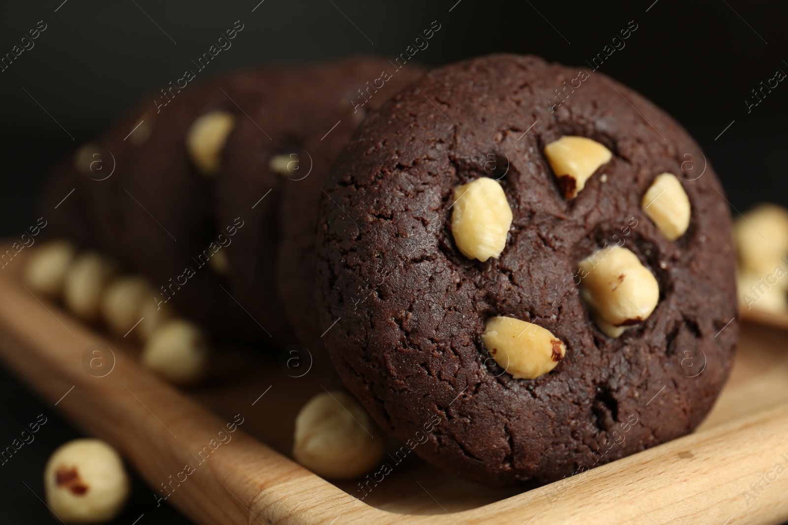 Photo of Delicious chocolate cookies with hazelnuts on table, closeup