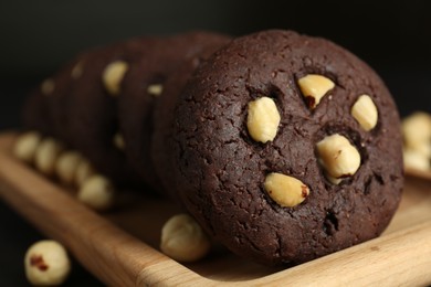 Photo of Delicious chocolate cookies with hazelnuts on table, closeup