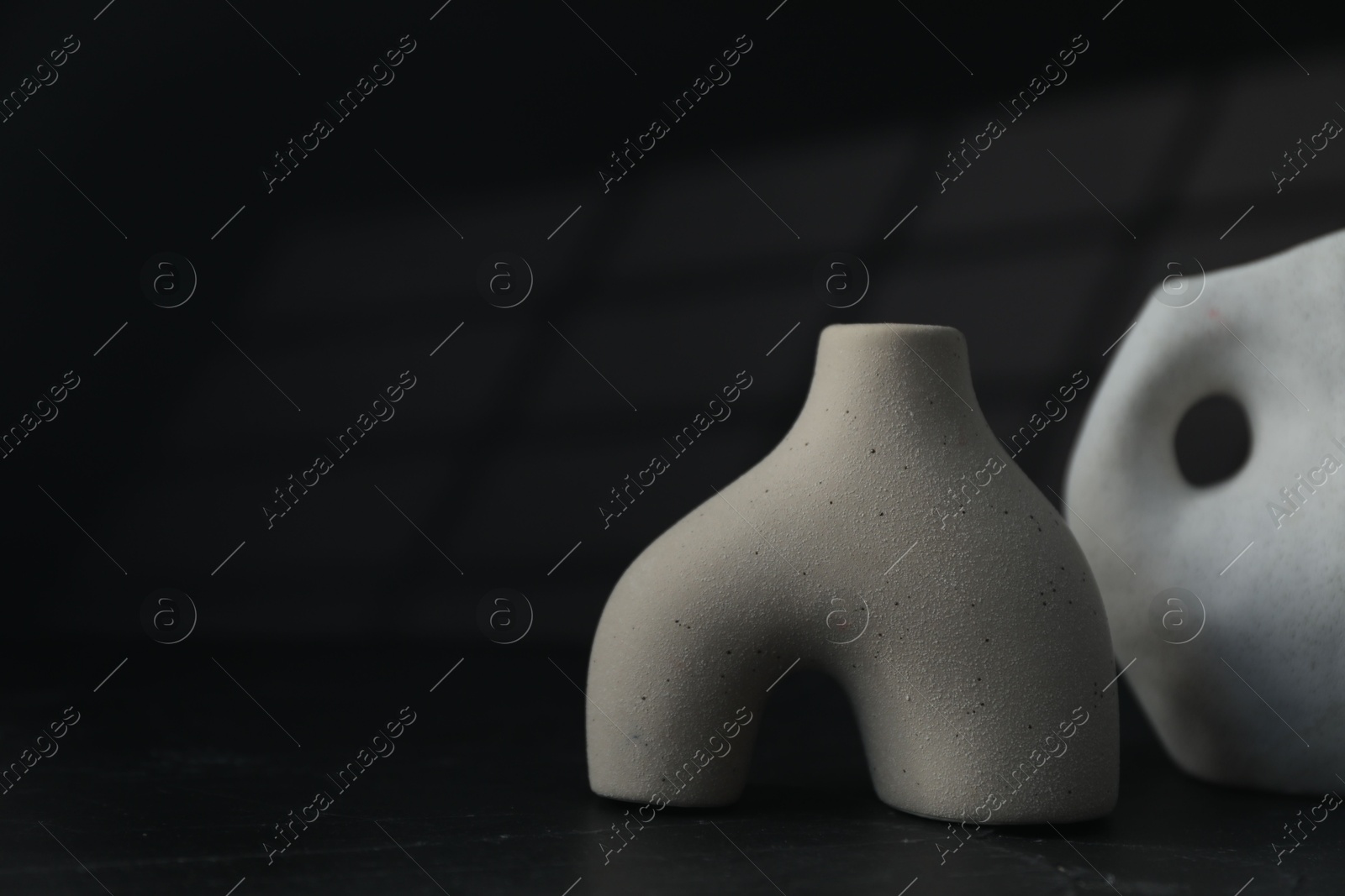 Photo of Stylish ceramic vases on black background. Space for text