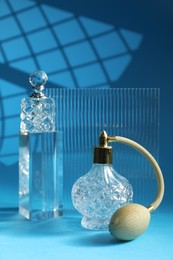 Photo of Stylish presentation of perfume bottles on light blue background