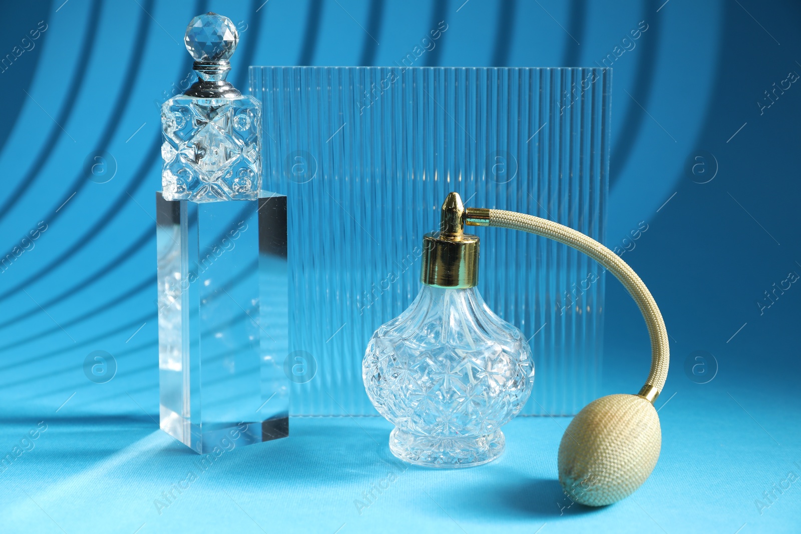 Photo of Stylish presentation of perfume bottles on light blue background