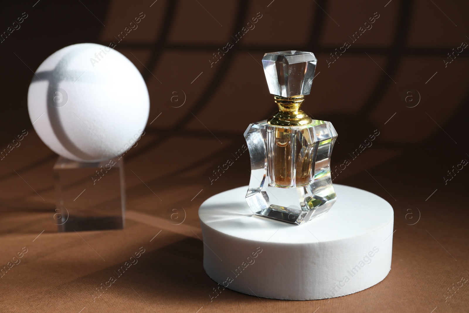 Photo of Stylish presentation of perfume bottle on brown background