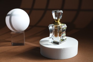 Photo of Stylish presentation of perfume bottle on brown background