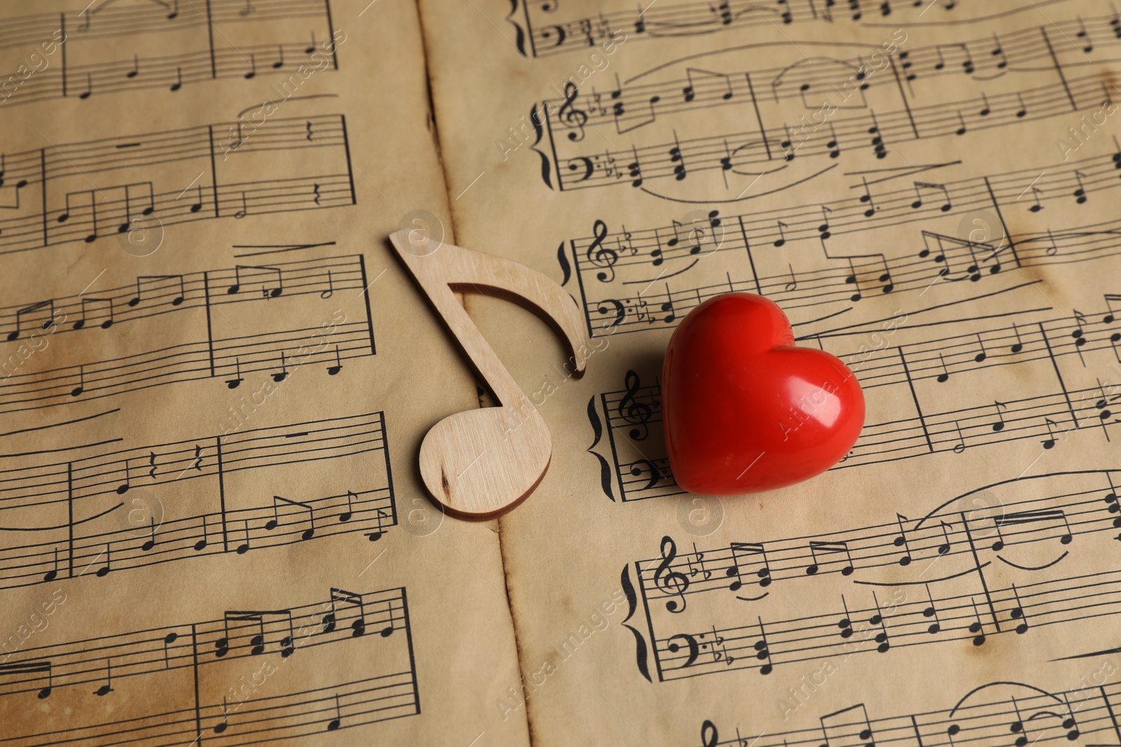 Photo of Heart and note figures on musical sheets, closeup