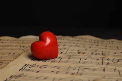 Photo of Heart figure and musical notes on black background, closeup