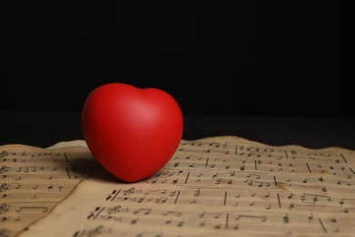 Heart figure and musical notes on black background, closeup