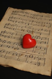 Heart figure and musical notes on black background, closeup