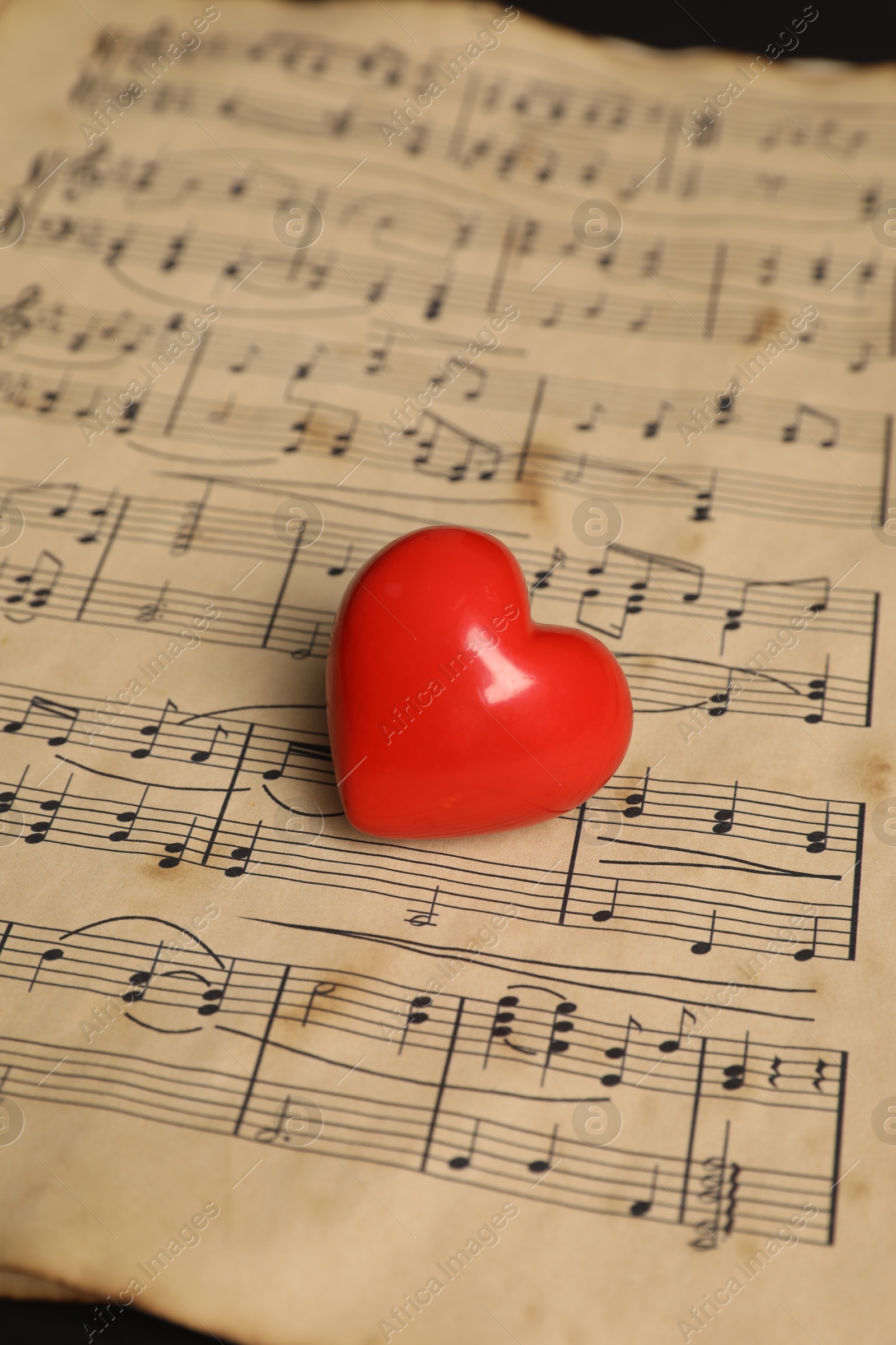 Photo of Heart figure and musical notes on black background, closeup