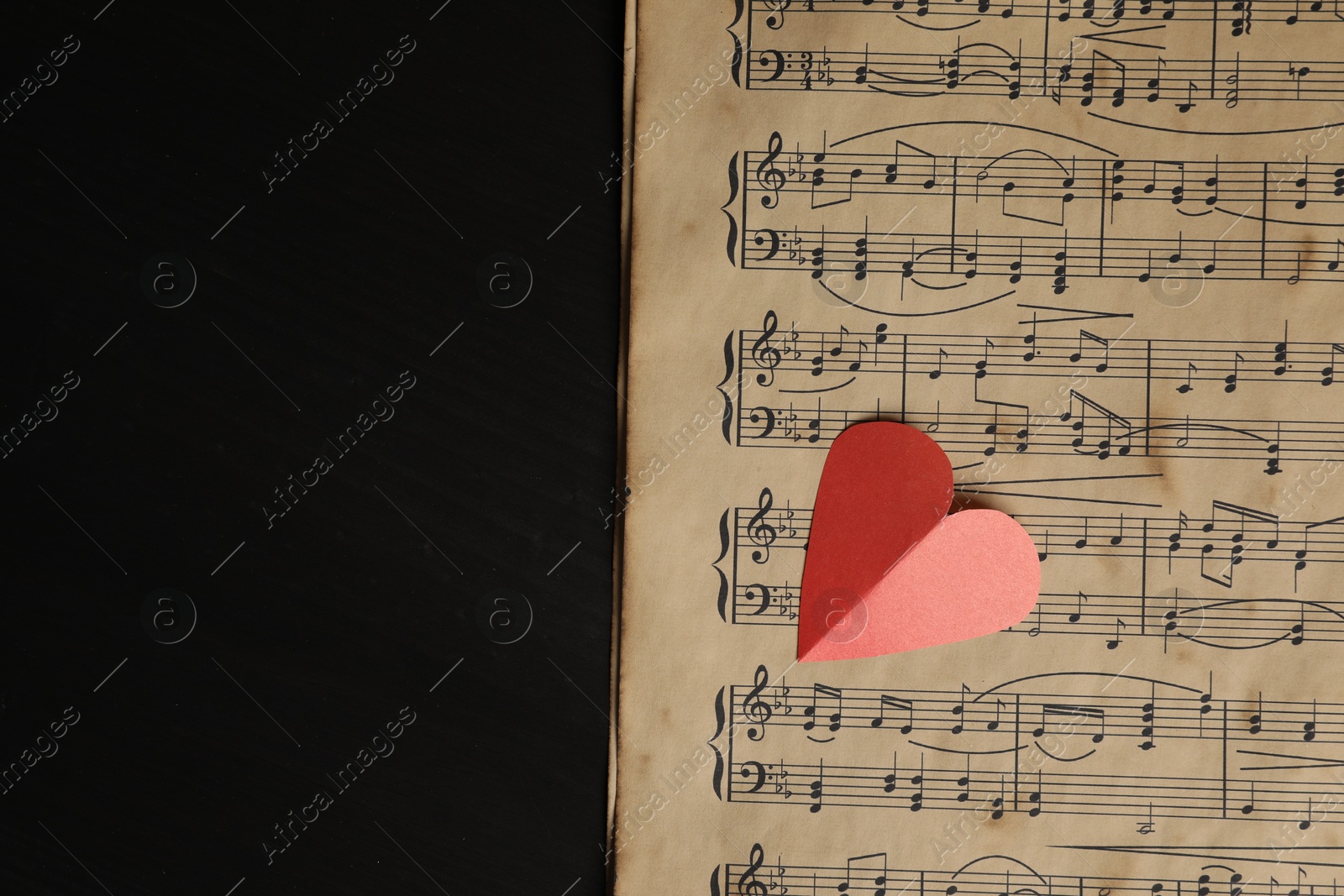 Photo of Paper heart and musical notes on black background, top view. Space for text